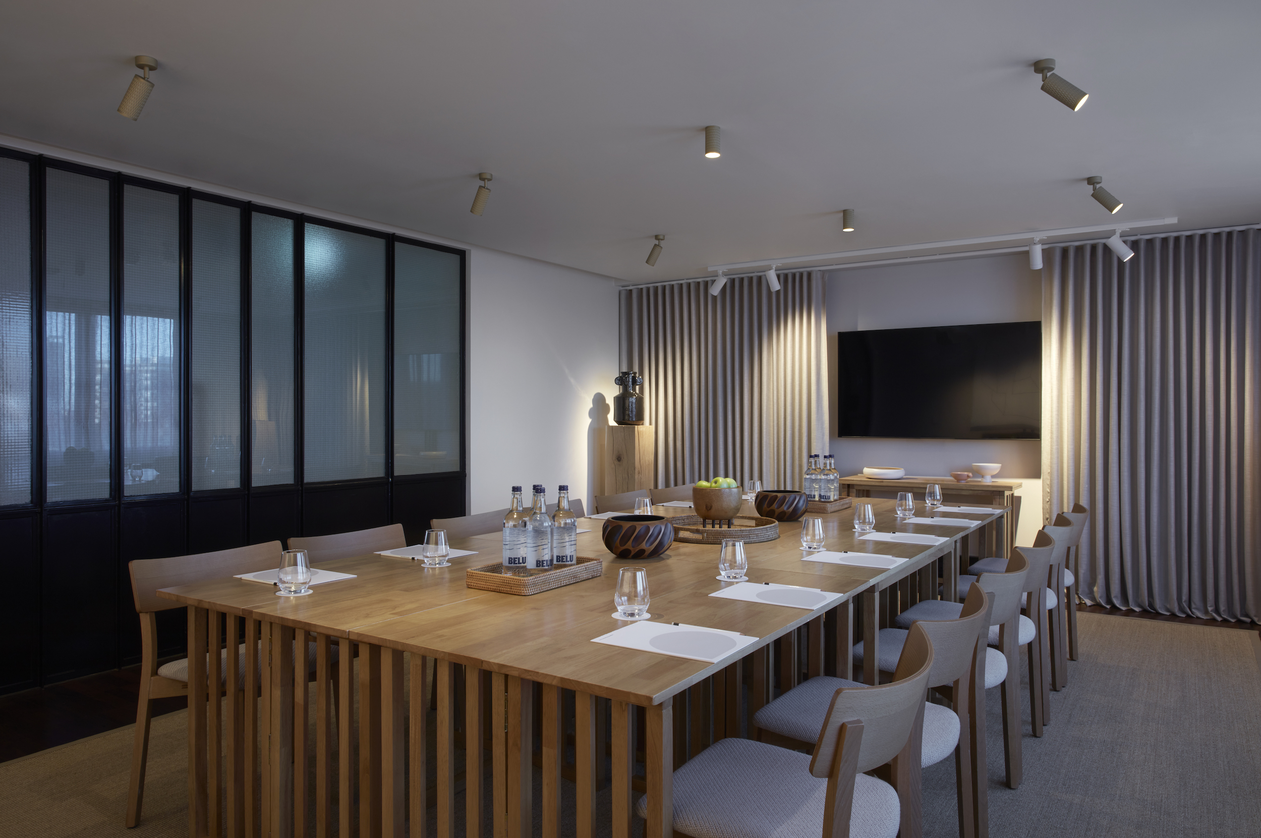 A conference room featuring wooden tables and chairs, designed for meetings and collaborative discussions.