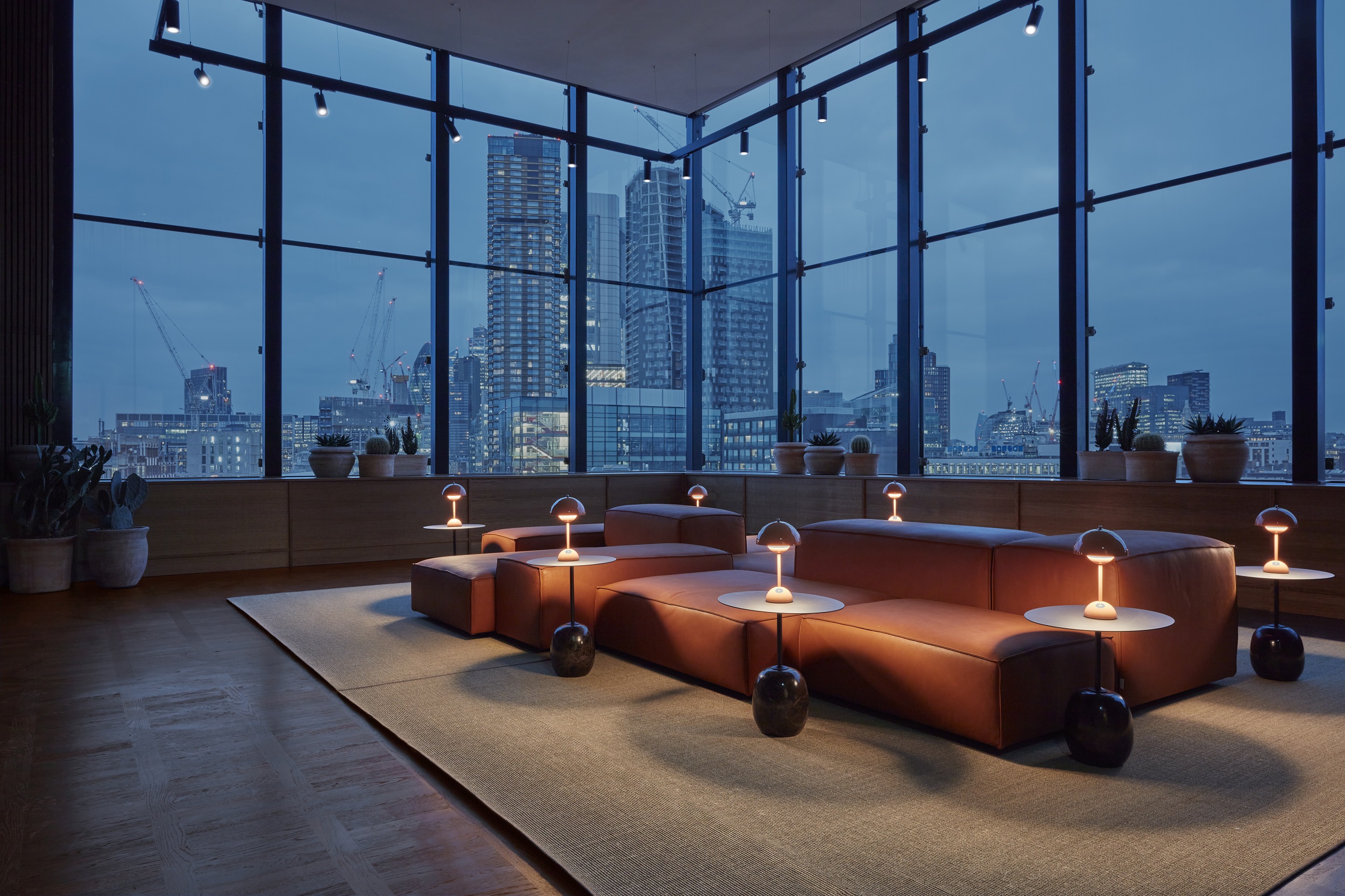 A cosy reception area featuring a stunning view of the London city skyline illuminated at night.